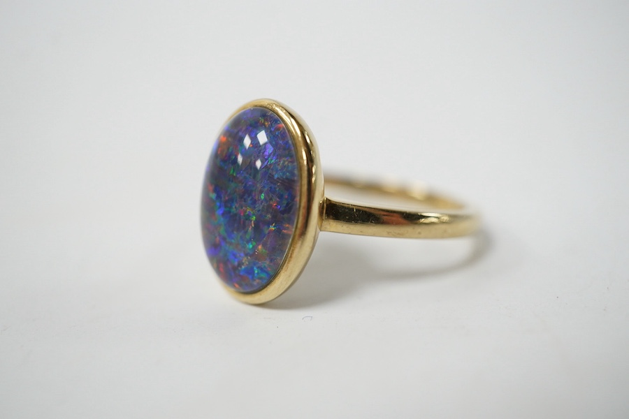 A modern 9ct gold and oval opal triplet set ring, size P/Q, gross weight 4 grams. Condition - good